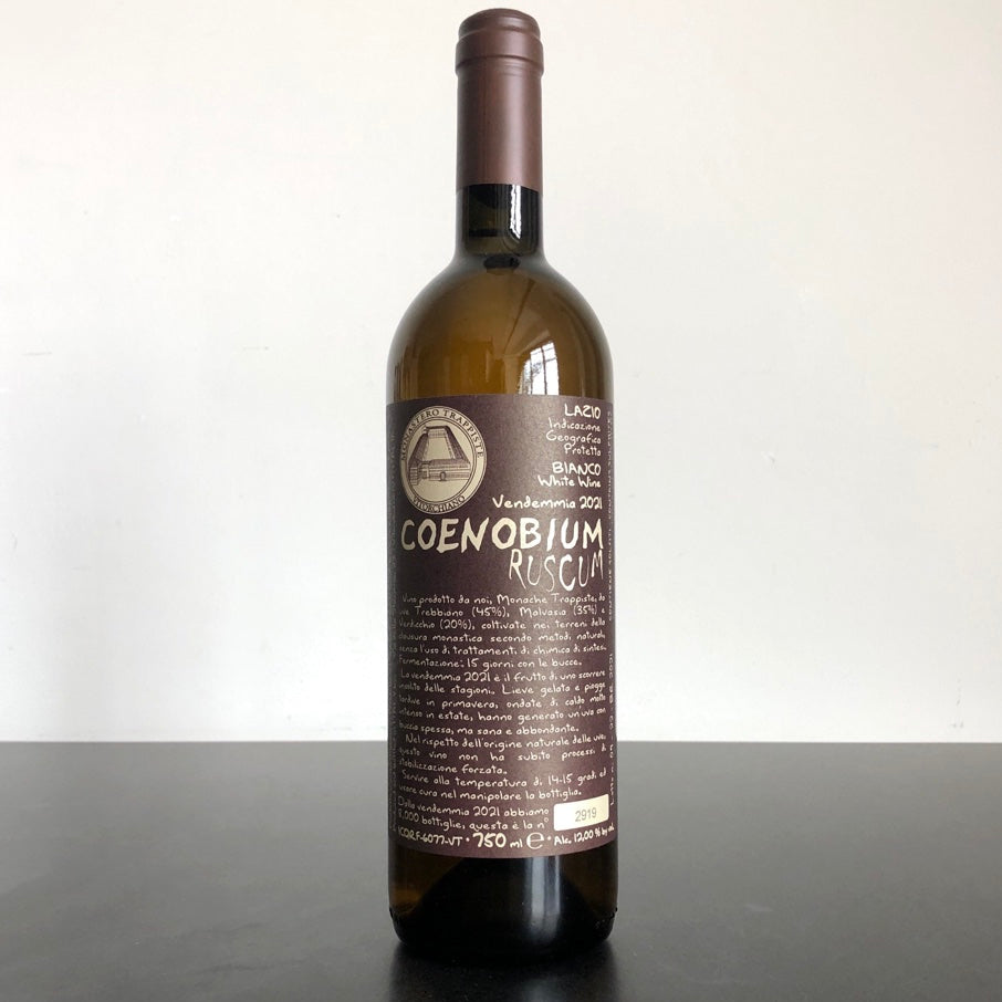 A bottle of 2022 Monastero Trappiste di Vitorchiano Coenobium Ruscum Bianco Lazio IGT wine with a label that includes the name of the wine and the grape varieties.